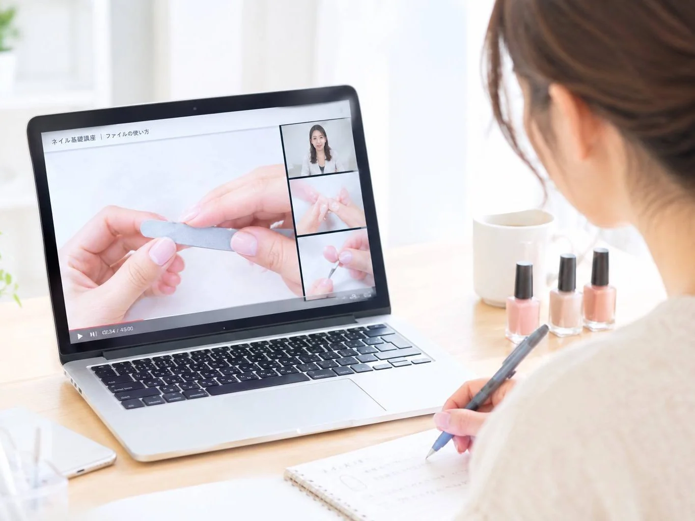 パソコンで動画を見て学ぶ女性