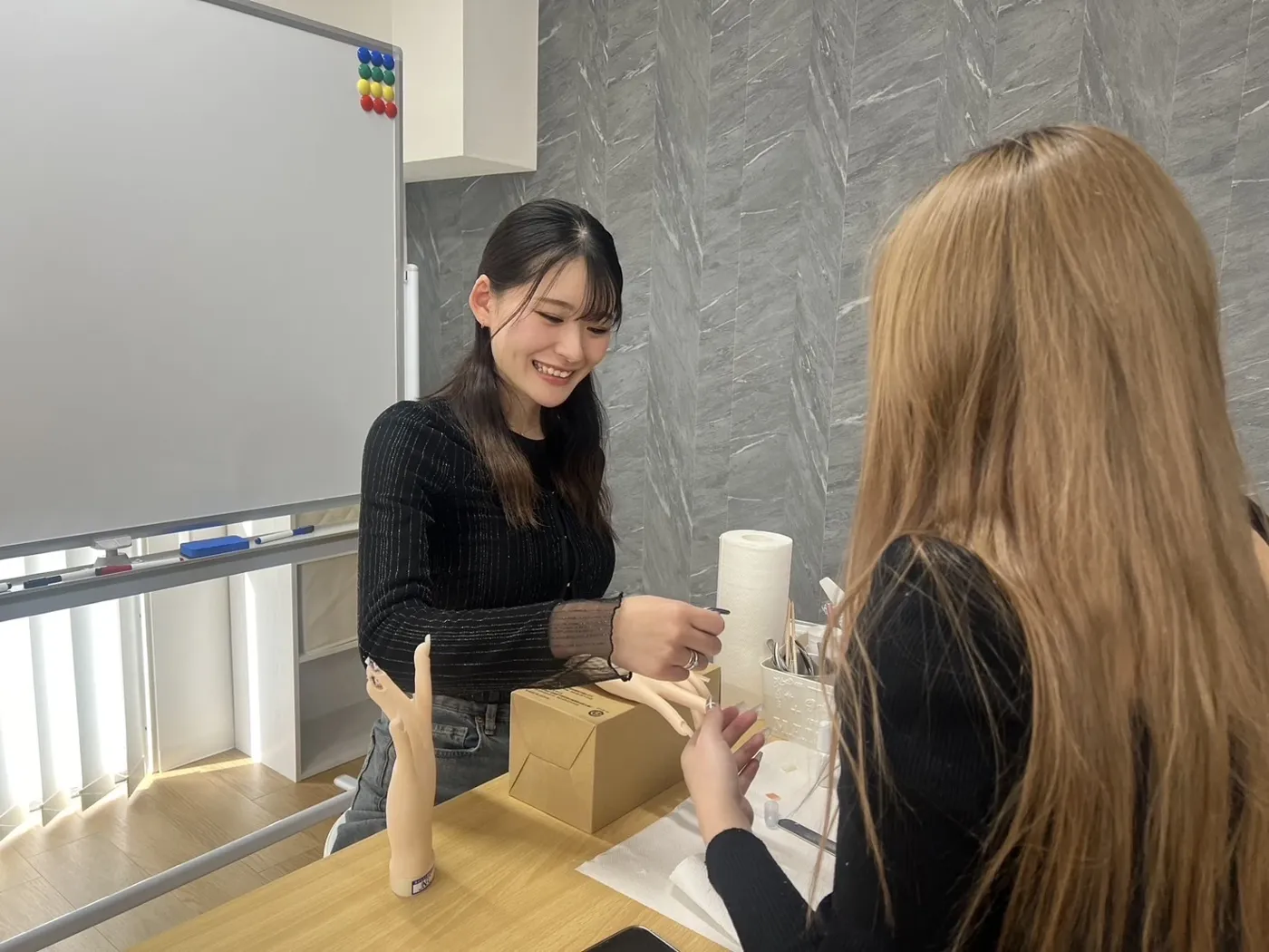 講師が受講生の手元を見ながら教える様子