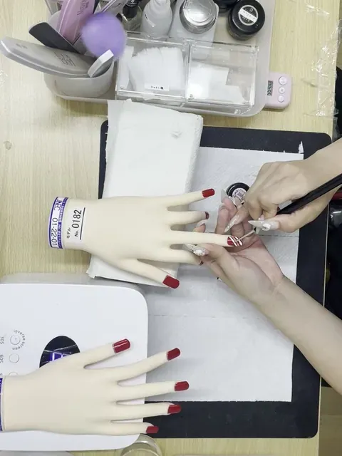練習用のハンドでネイルを学ぶ手元
